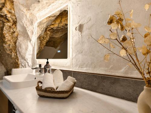 a bathroom with a sink and a basket with towels at La Cueva De Orel in Molinicos