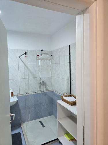 a bathroom with a shower and a sink at Puzzle Apart Rooms in Tirana
