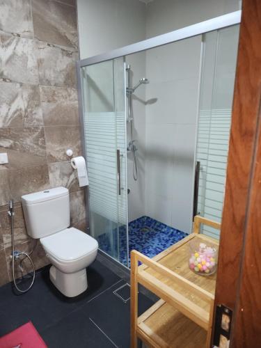 a bathroom with a toilet and a glass shower at Al-Amaari Gardens Compound 3091 in Irbid