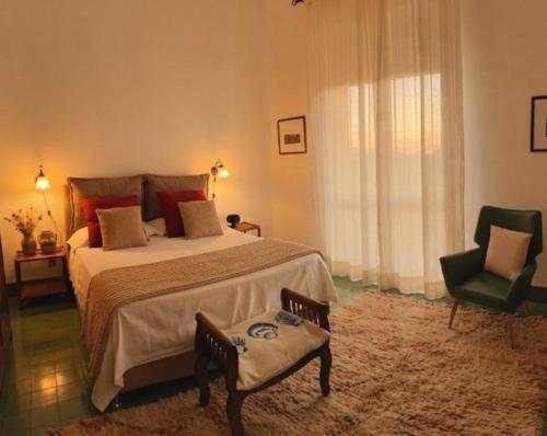 a bedroom with a large bed and a chair at Il Mulino in Locri