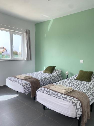 two beds in a room with a window at Villa Verano Apartamentos Compartidos Villaverde in La Oliva