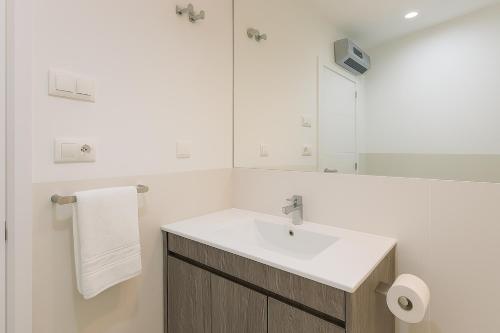 a white bathroom with a sink and a mirror at City Center R3 in Nerja