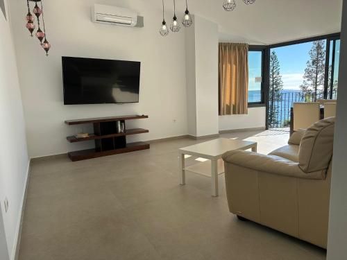 a living room with a couch and a flat screen tv at City Center R3 in Nerja