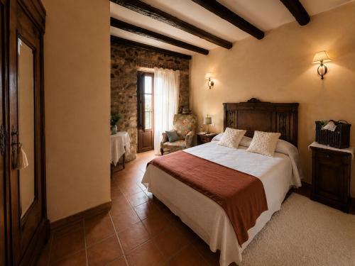 a bedroom with a bed and a chair in a room at Casa Rural Canchalejo in Montánchez