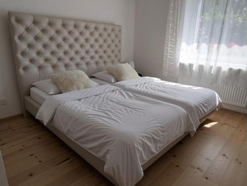 a white bed in a bedroom with a large window at Apartmán Sofie in Poděbrady