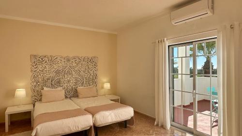 ein Schlafzimmer mit einem Bett und einem großen Fenster in der Unterkunft Abby - Private Pool - 11 Guests - Albufeira in Albufeira
