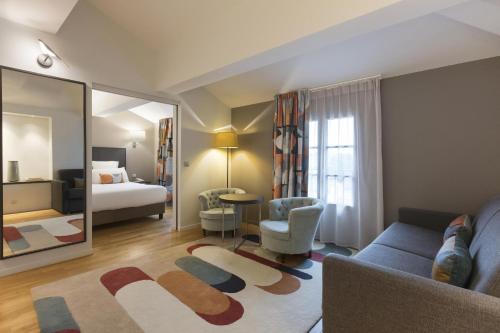 a living room with a couch and a mirror at Best Western Grand Hotel de Castres in Castres