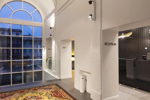 a lobby with a large window and a rug at Best Western Grand Hotel de Castres in Castres