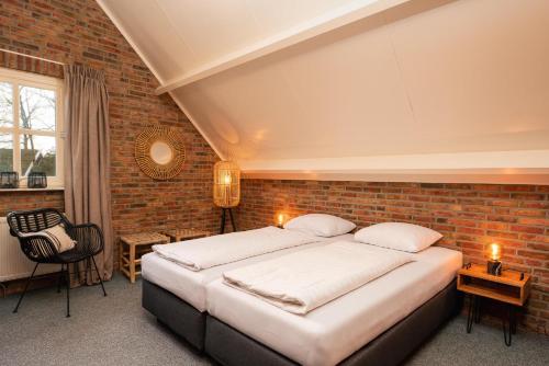a bedroom with a bed and a brick wall at De Bron | 1-8 pers. in Losser