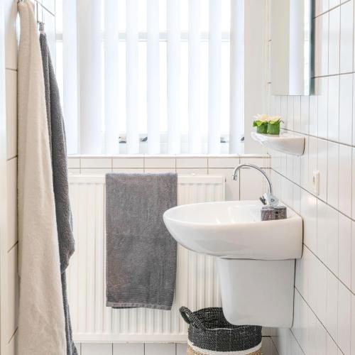 a white bathroom with a sink and a mirror at De Bron | 1-8 pers. in Losser