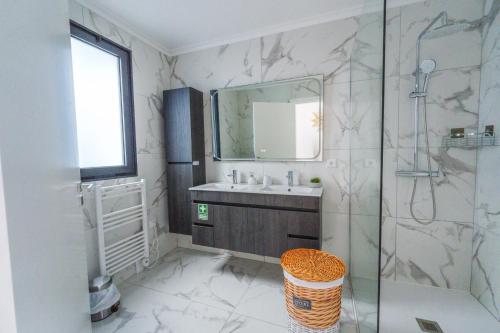 a bathroom with a sink and a shower with a mirror at Eva's house in São Vicente