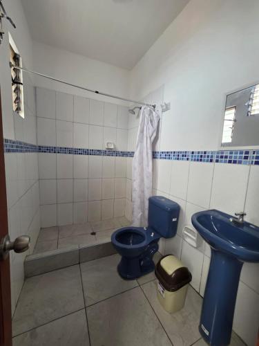 a bathroom with a blue toilet and a sink at Javaz Hospedaje in Tarapoto