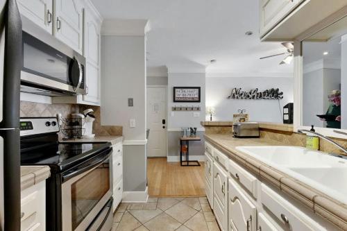 a kitchen with white cabinets and a sink and a stove at Polk 401 in Nashville