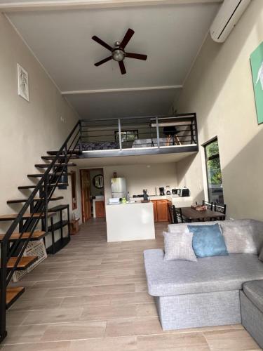a living room with a couch and a ceiling fan at Nani House in Montezuma