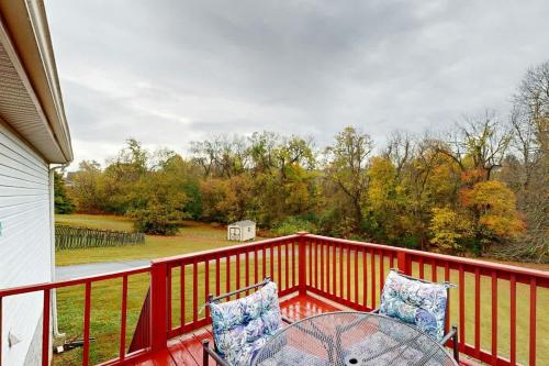 a balcony with a table and chairs on a red railing at Mount Juliet Charmer in Hunters Store