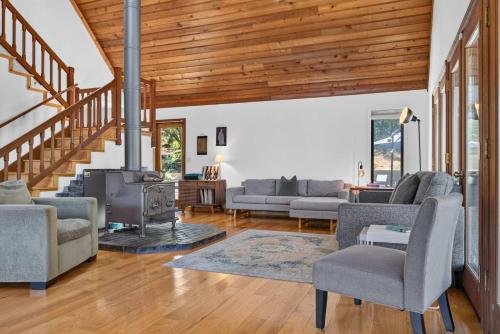 a living room with a fireplace and wooden ceilings at Sunny Grove Retreat in Sebastopol