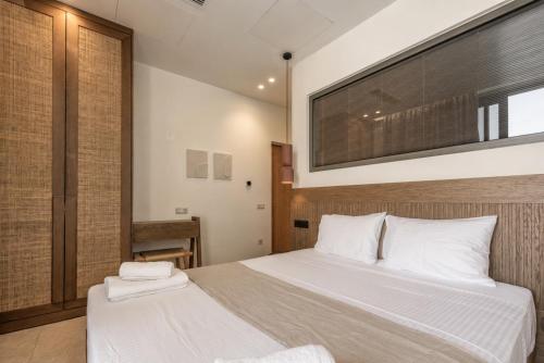 a bedroom with a large white bed and a window at Deciel Cave Villa in Áyios Pétros
