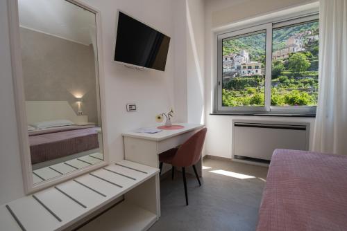 a bedroom with a desk and a bed and a mirror at Casa Vacanza San Pietro in Maiori