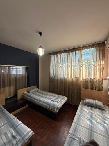 a bedroom with two beds and a window at D&A hotel in Yerevan