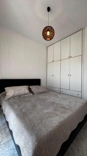 a bedroom with a large bed with white cabinets at The Fernvills in Nea Kallikrateia