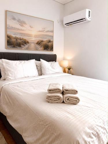 a bedroom with a white bed with towels on it at Oli' Studio in Oropos