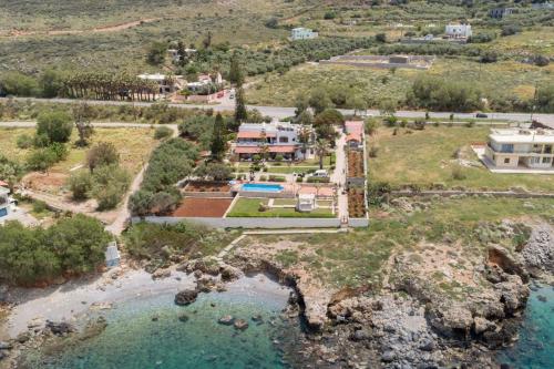 an aerial view of a house next to a body of water at Beachfront Family Villa Katerina with Private pool, Playground, BBQ & Amazing Sea Views! in Petres