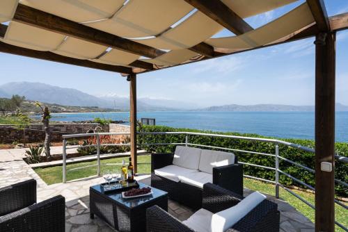 a patio with a view of the ocean at Beachfront Family Villa Katerina with Private pool, Playground, BBQ & Amazing Sea Views! in Petres
