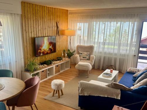 a living room with a blue couch and a tv at Appartement de vacances - ski-in ski-out in Veysonnaz