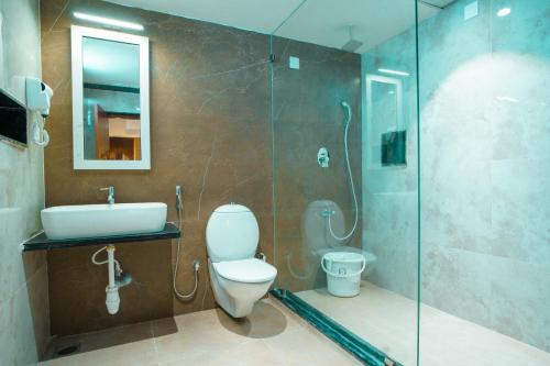 a bathroom with a toilet and a sink and a shower at Sri Vishnu Grand in Vellore