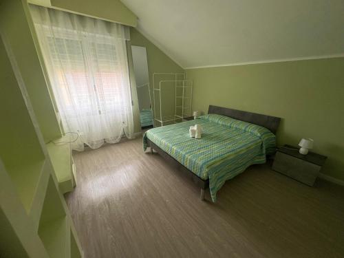 a green bedroom with a bed and a window at La Concordia Serravalle Outlet in Serravalle Scrivia