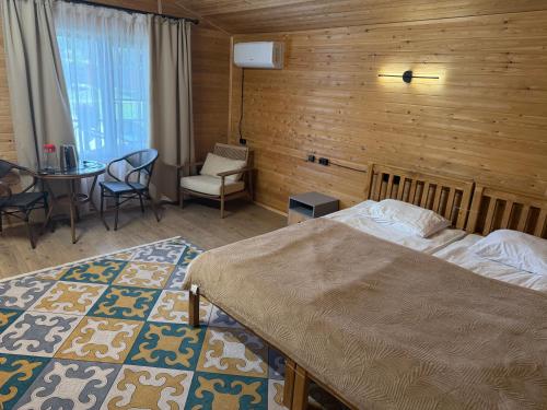 a bedroom with a bed and a table and chairs at Kolsay Eco House in Saty
