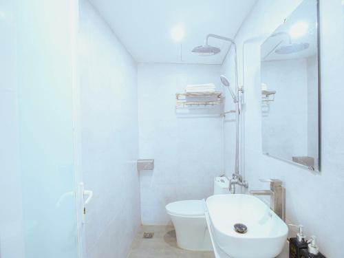 a white bathroom with a toilet and a sink at Khách sạn Phúc Thành in Hanoi