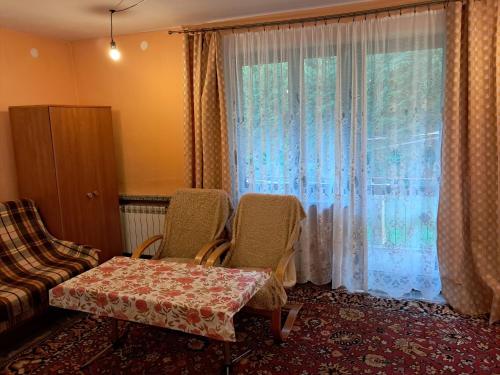 a room with a table and chairs and a window at Kwatery u Potoków in Piwniczna-Zdrój