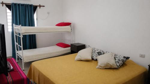 a bedroom with two bunk beds and a yellow bed at La casa de Piscis in Termas de Río Hondo