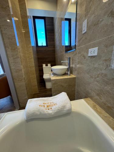 a bathroom with a white towel on a tub at Hotel San Miguel Cusco in Cusco