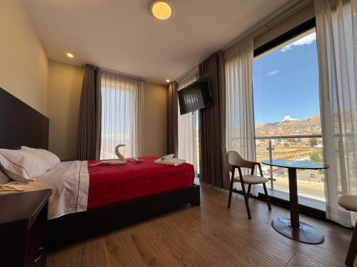 a bedroom with a bed and a table and a window at Hotel San Miguel Cusco in Cusco