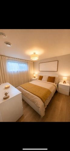 a bedroom with a large bed and a table at Modern private apartment - Warm atmosphere in Repentigny