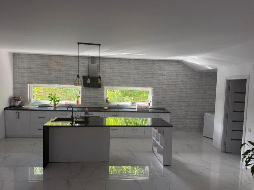 a kitchen with a black counter top and two windows at AME Home Apartament 2 in Ocna-Mureşului