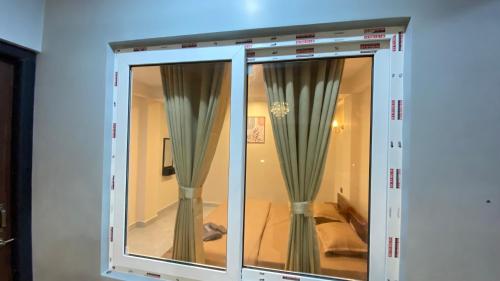 a glass door with curtains in a room at Stayat77 in Karsiyang