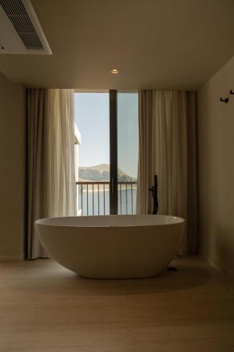 a large bath tub in a room with a window at Asfiya Sea View Hotel in Kalkan