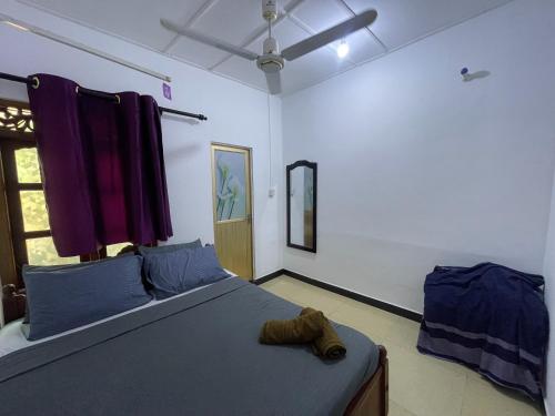 a bedroom with a bed with blue sheets and a window at ocean breeze in Challi