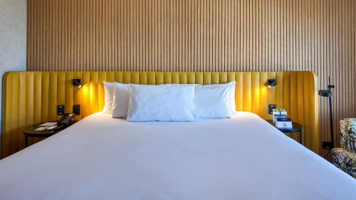 a large bed with white pillows in a hotel room at Grand Mercure SP Pinheiros in São Paulo
