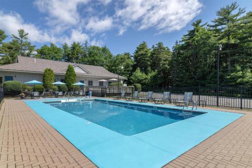 a large swimming pool with chairs and a fence at Best Western Acadia Park Inn in Bar Harbor