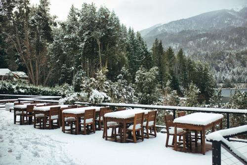 a group of tables and chairs covered in snow at Auria Angostura in Villa La Angostura