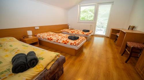 a room with two beds and a desk at Chata Motocentrum in Snina