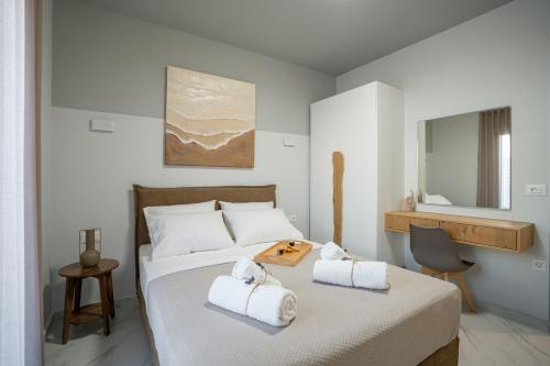 a bedroom with a bed with towels on it at Agora Luxury Suites in Lixouri