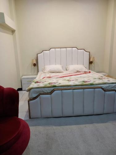 a bed with a white frame in a room at Asghar Ali Resort in Lower Topa