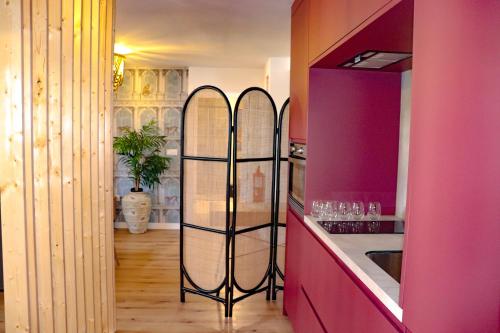 a kitchen with pink walls and a counter with two surfboards at Diana Boutique Apartamentos in Mérida