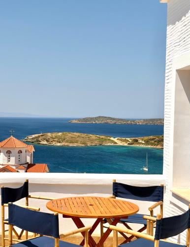 a table and chairs on a balcony with a view of the ocean at Andros Villa in Andros
