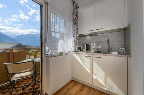a kitchen with a large window and a table at Alpenplatzl XS in Bad Hofgastein